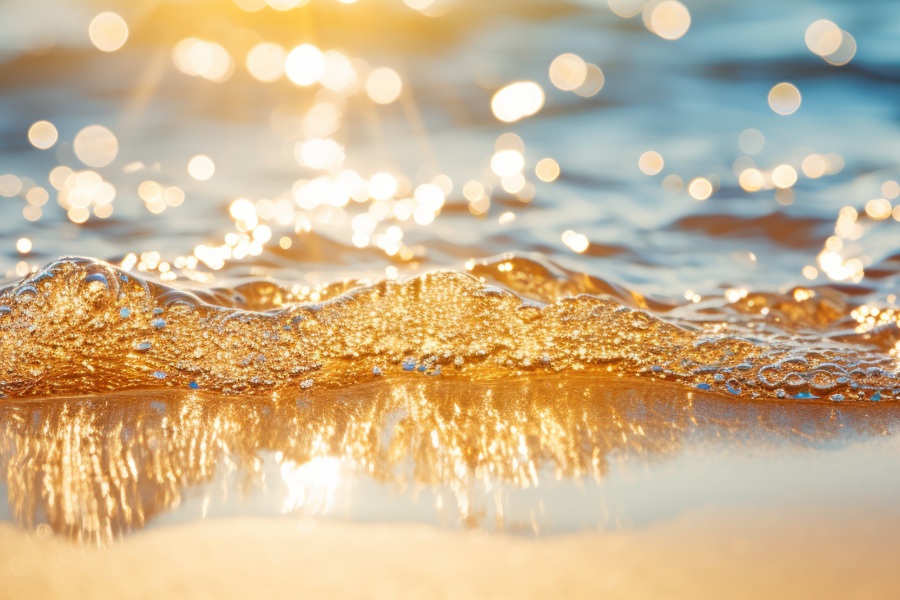 The beach glows with a warm, amber light as waves gently lap the sand.