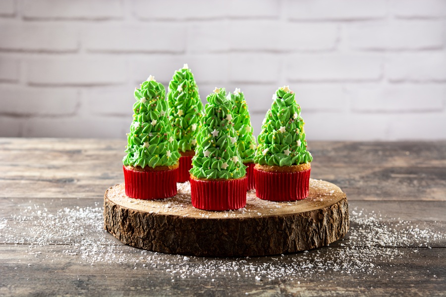 Christmas tree cupcakes on wooden table